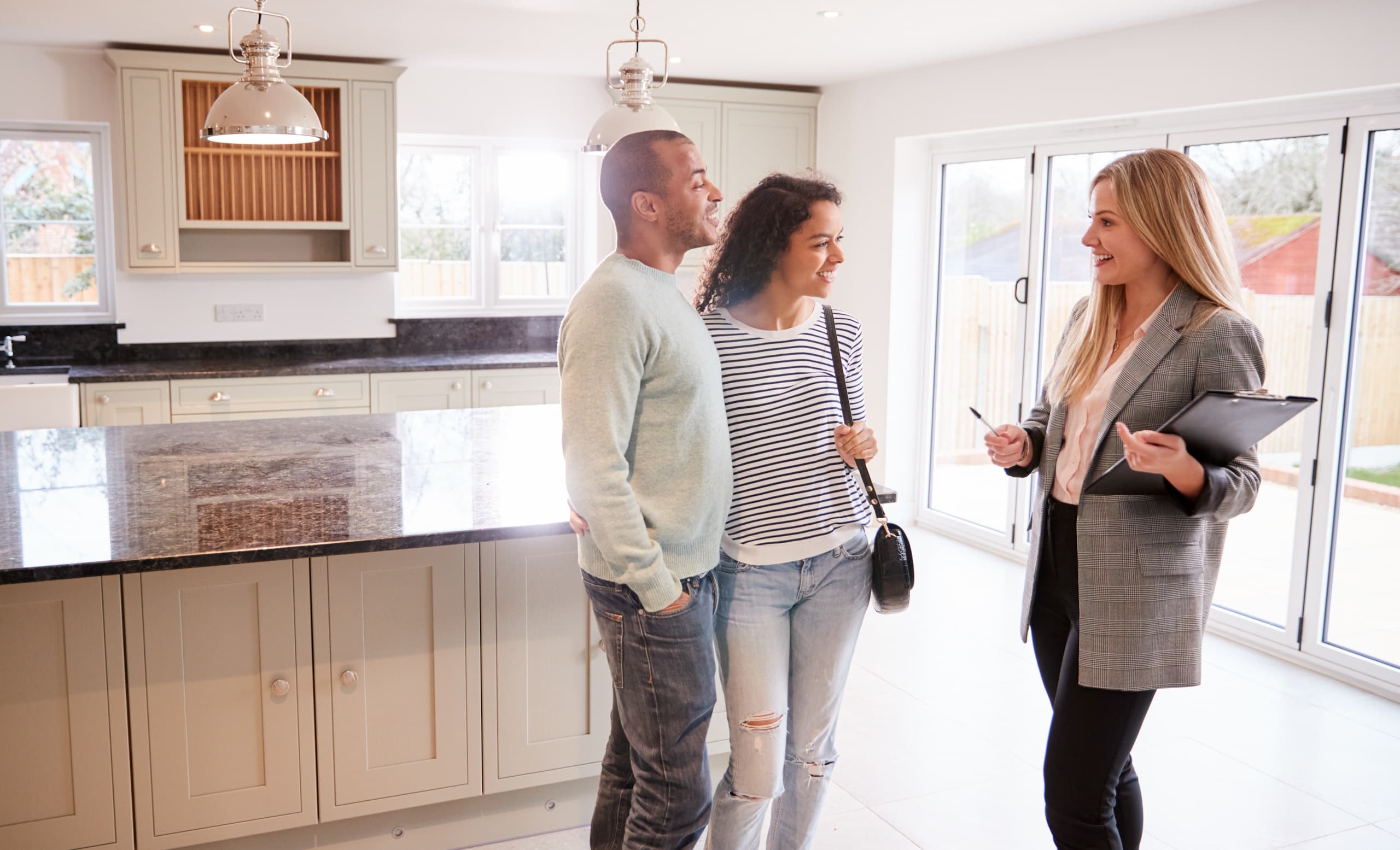 Home buyers at open house with a real estate agent / open house tips when selling your home